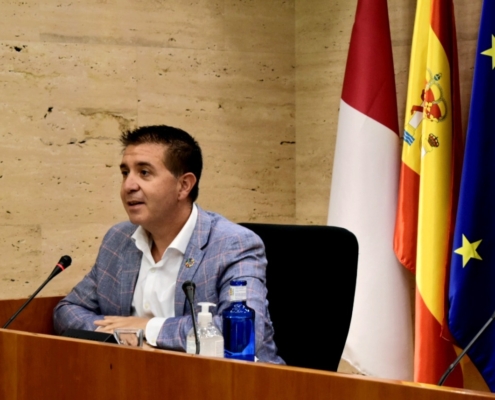 El presidente de la Diputación de Albacete, Santi Cabañero, aparece hablando ante un micrófono, sentado a una mesa detrás de la que lucen las  ...