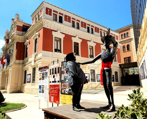 Plano general de la entrada al Palacio de la Diputación, con las estatuas de Don Quijote y Sancho Panza vistiendo indumentaria típica manchega