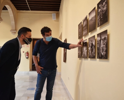 El diputado de Cultura, Miguel Zamora, atiende a las explicaciones del fotógrafo Javier Arcenillas durante la inauguración de la exposión City Hope