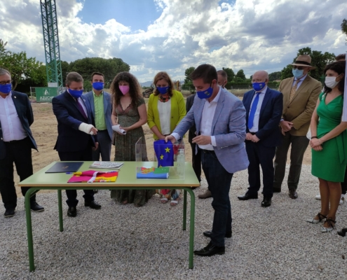 El presidente de la Diputación introduciendo la bandera de la UE en la urna de Primera Piedra del CEE Cruz de Mayo de Hellín