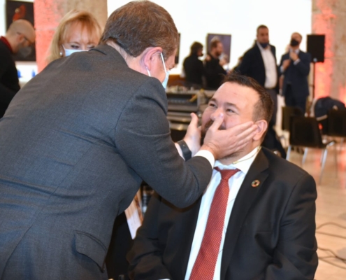 El presidente regional, Emiliano García-Page, saluda afectuosamente (cogiendo su cara) al alcalde de La Roda y vicepresidenta provincial, Juanra  ...