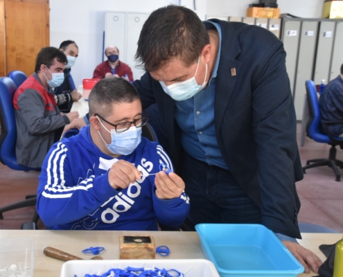 El presidente de la Diputación observa como un usuario de Asprona trabaja en el Centro Ocupacional Eloy Camino de la entidad