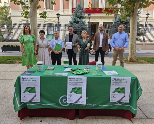 Foto de familia en la cuestación de la AECC con el Palacio Provincial de fondo