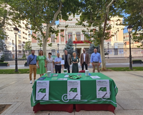 Foto de familia en la cuestación de la AECC con el Palacio Provincial de fondo